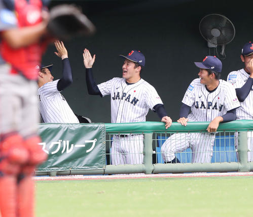 中国対日本　2回裏日本2死一、三塁、日置航の勝ち越しの左前適時打で笑顔でタッチを交わす吉田（中央）と中川（左）（撮影・垰建太）