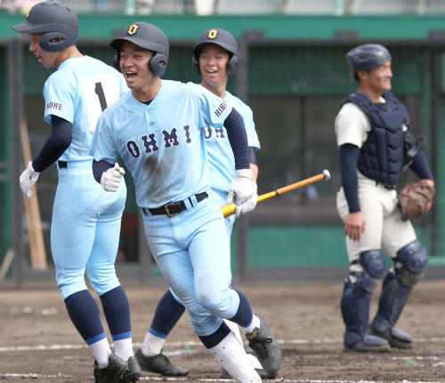 近江対高知商　8回表近江1死三塁、瀬川（手前）は右越え2点本塁打を放ち笑顔で生還（撮影・上山淳一）