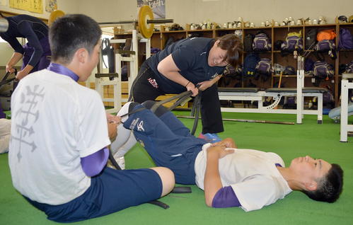 選手らと交流を図りながらトレーニングを行う冨田トレーナー（中央）
