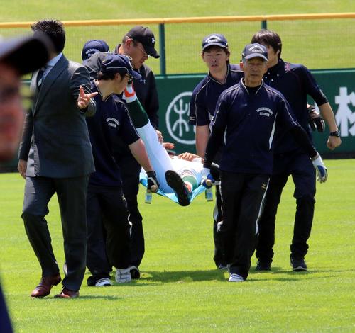 帯広緑陽対帯広工　9回裏帯広工1死、左前打を処理した後、右ふくらはぎがつって立てなくなり担架で運ばれる帯広緑陽の前田左翼手（撮影・永野高輔）