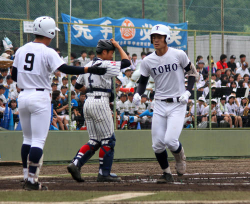 天白対東邦　1回裏東邦1死一塁、右中間に先制2点本塁打を放ち、生還する東邦・石川（右）（撮影・柏原誠）