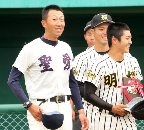 試合後に敗れた明桜の選手たちに両チームで記念写真を撮ろうと促す弘前学院聖愛・原田監督（左）（2019年6月11日撮影）