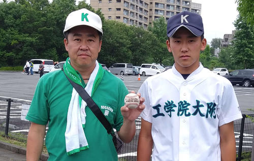 息子太吾（右）から受け取ったホームランボールを手にする父博之さん（撮影・飯岡大暉）