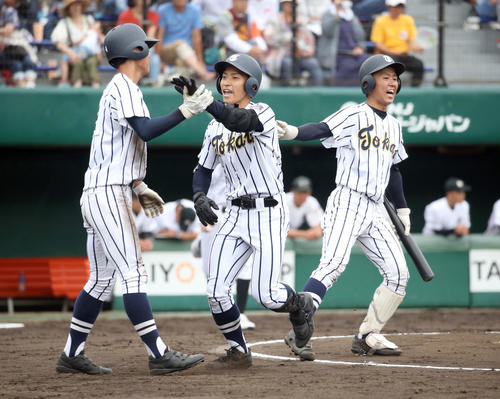 東海大札幌対鵡川　2回裏東海大札幌1死一塁、左越え2点本塁打を放ちチームメートに出迎えられる鈴木（中央）（撮影・佐藤翔太）