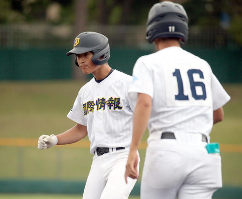 札幌国際情報対札幌平岡　7回裏札幌国際情報2死一、三塁、右前適時打を放ちガッツポーズをする高橋（左奥）（撮影・佐藤翔太）