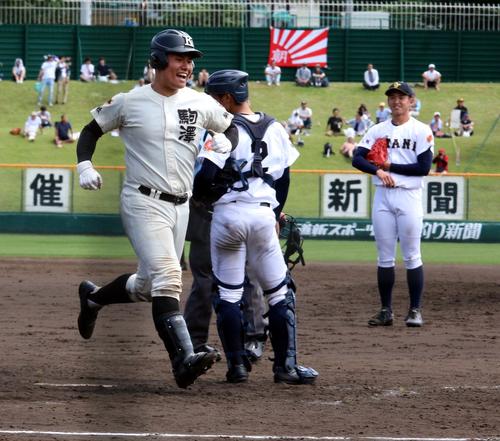 札幌大谷対駒大苫小牧　5回駒大苫小牧、無死一塁、逆転2ランを放った竹中捕手（左）が声をあげながら生還する。右端は札幌大谷エース西原（撮影・永野高輔）