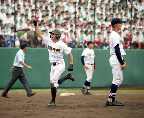 札幌国際情報対北海　サヨナラ打を放ちガッツポーズをしながらチームメートの元に向かう札幌国際情報須田。右は打たれた北海井村（撮影・佐藤翔太）
