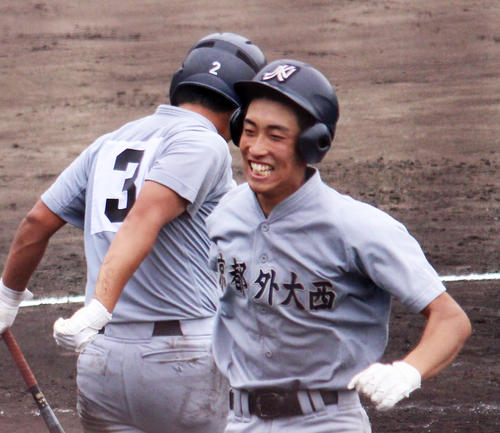 京都外大西の山下航汰外野手（2年）は3点リードの7回1死、中越え場外弾を放ち、笑顔でホームイン（撮影・佐井陽介）