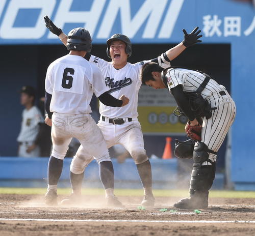 明桜対秋田中央 11回裏秋田中央2死二塁、サヨナラ打を放った斎藤光(中央)。右は明桜の加藤(撮影・山田愛斗)