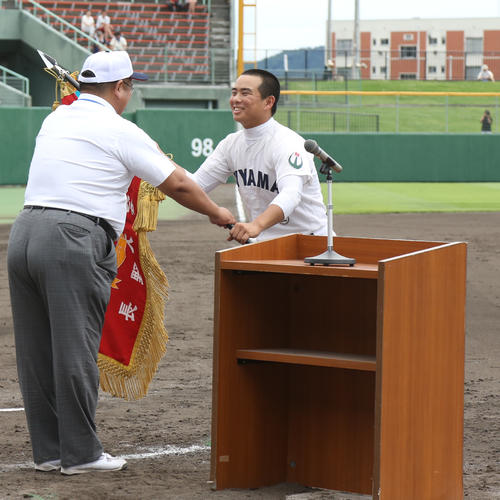 笑顔で優勝旗を受け取る飯山・大川主将(撮影・佐田亮輔)