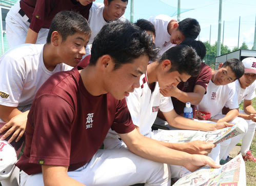 北北海道大会優勝から一夜明け、旭川大高の2連覇を伝える日刊スポーツに目を通す持丸主将（手前）ら選手たち（撮影・浅水友輝）