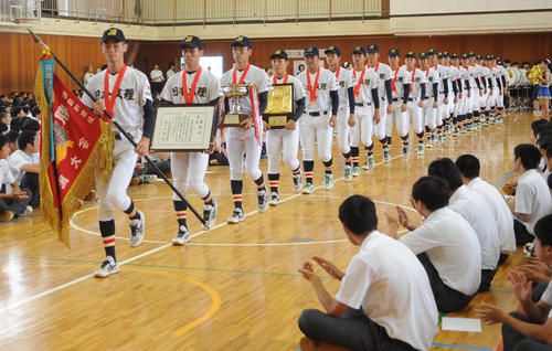 全校生徒が見守る中、優勝旗を持った長坂主将を先頭に入場する日本文理ナイン