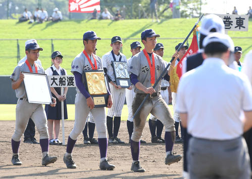 花巻東対大船渡　優勝して行進する花巻東の選手を見つめる大船渡・佐々木（後方中央）（撮影・山崎安昭）