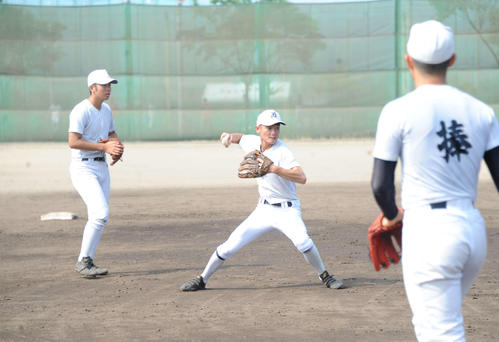 ノックで軽快にゴロをさばく長坂主将（中央）（撮影・斎藤慎一郎）