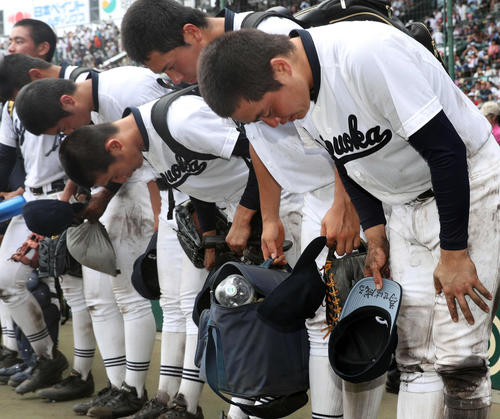 津田学園対静岡　「為せば成る」と帽子のつばに書き込んだ静岡・小岩主将（右端）だったが、初戦敗退で仲間と一緒にグラウンドにあいさつして引き揚げる（撮影・松本俊）