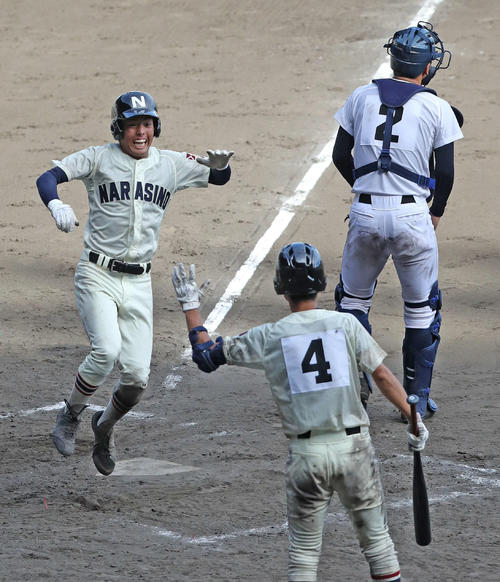 習志野対沖縄尚学　9回表習志野1死一、三塁、角田の左前適時打で飛びはねて生還する三走山内（左）（撮影・松本俊）