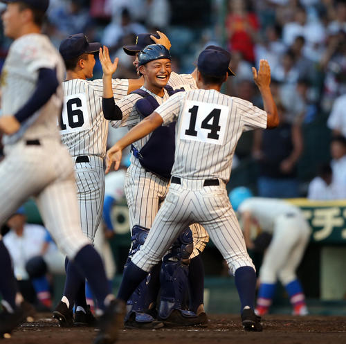 花咲徳栄対明石商　勝利し、笑顔で百々（右）とハイタッチする水上（中央）（撮影・大野祥一）