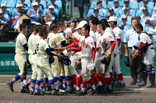 智弁和歌山対星稜　14回の激闘を終え、笑顔を見せながら握手を交わす智弁和歌山ナイン（右）と星稜ナイン（撮影・前田充）