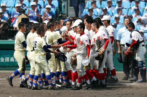 智弁和歌山対星稜　14回の激闘を終え、笑顔を見せながら握手を交わす智弁和歌山ナイン（右）と星稜ナイン（撮影・前田充）