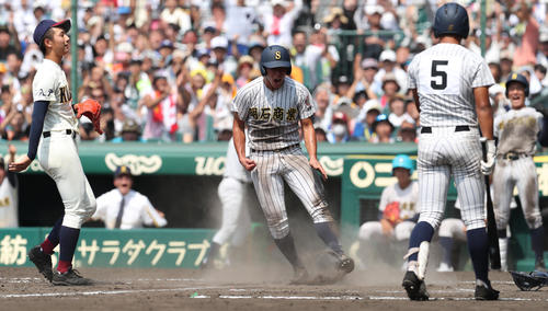 明石商対八戸学院光星　8回表明石商2死三塁、山田（左）の暴投で三塁から勝ち越しの生還をした来田はガッツポーズ（撮影・宇治久裕）