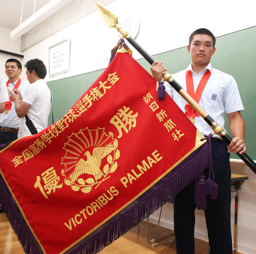決勝戦から一夜明け学校で優勝旗を手にする野口主将（撮影・上山淳一）