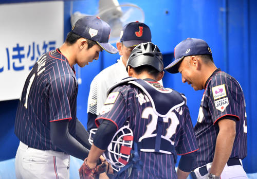 26日、1回裏を終え、仲井コーチ（右）に指を確認してもらう大船渡・佐々木（左）