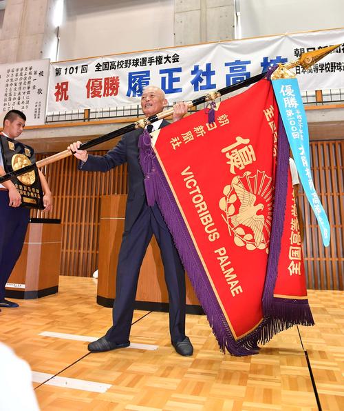 優勝報告会で優勝旗を手に笑顔を見せる履正社・小森重喜校長（撮影・上田博志）