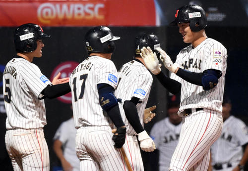 日本対パナマ　5回裏日本2死一、三塁、左越え3点本塁打を放ちナインとタッチを交わす石川（右）（撮影・横山健太）