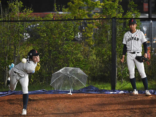日本対パナマ　試合中、ブルペンで投球練習する佐々木（左）と奥川（撮影・横山健太）