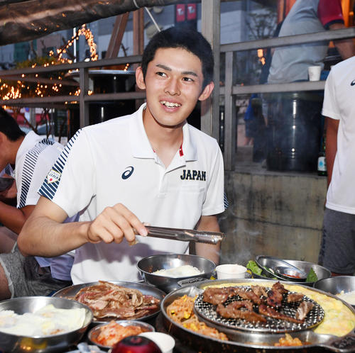 決起集会でうれしそうに肉を焼く佐々木（撮影・横山健太）