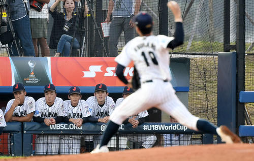 日本対カナダ　奥川（手前）の投球をベンチから見つめる佐々木（左から4人目）（撮影・横山健太）
