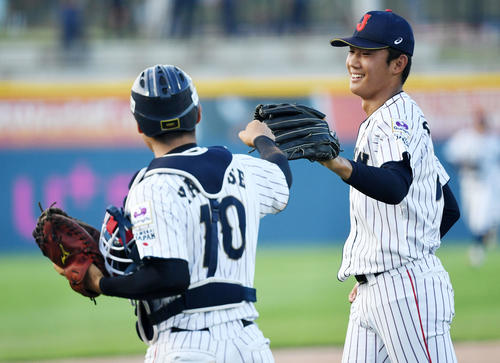 日本対カナダ　1回表を無失点に抑えタッチを交わす奥川（右）と山瀬（撮影・横山健太）