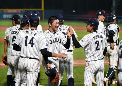 日本対カナダ　カナダに勝利しタッチを交わす飯塚（中央）ら日本ナイン（撮影・横山健太）
