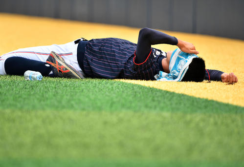 日本対韓国　タオルを顔にかけストレッチをする佐々木（撮影・横山健太）