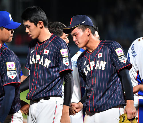 日本対韓国　試合後、韓国ナインと握手を交わす佐々木（左）と石川（撮影・横山健太）