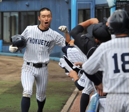 北越対上田西　6回北越1死二塁、佐藤圭遊撃手の右前打で生還し、ベンチのチームメートとハイタッチする松山中堅手（撮影・山岸章利）