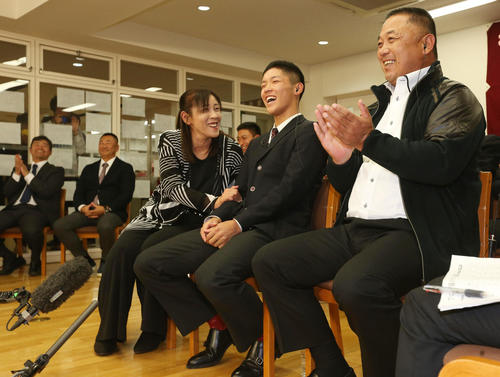 ドラフト会議でヤクルトから6位指名を受けた八戸学院光星・武岡（中央）は、母みどりさん（左）、父克明さん（右）と喜ぶ。後方左から同校の小坂部長、仲井監督（撮影・野上伸悟）