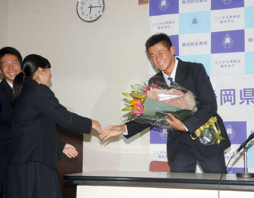 野球部の仲間から花束を贈られ、照れ笑いの紅林（撮影・河合萌彦）