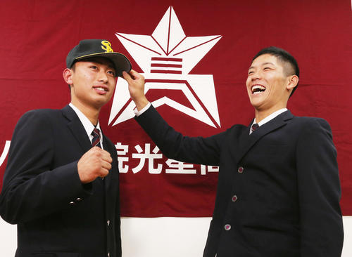 ヤクルトから6位指名を受けた八戸学院光星・武岡（右）は、ソフトバンクから育成3位指名の伊藤に帽子をかぶせ笑顔（撮影・野上伸悟）