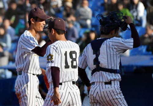 城東対国士舘　完封勝利しナインとタッチを交わす国士舘・中西（左）（撮影・滝沢徹郎）