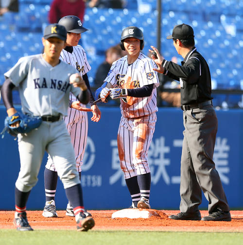 関大対東海大　1回裏東海大2死一、二塁、左中間を破る2点適時三塁打を放ち笑顔の小松（中央）。左は関大・牧（撮影・大野祥一）