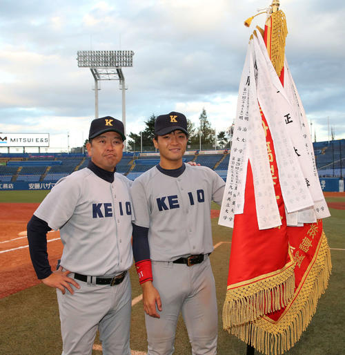 慶大対関大　優勝旗と写真に納まる慶大・大久保監督（左）と郡司（撮影・鈴木正人）