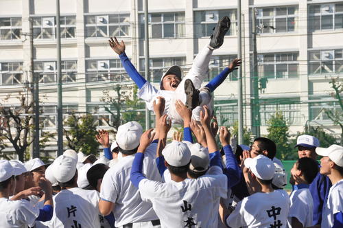 塾長の星稜山下名誉監督と尼崎工ナインらはマシンガンノックを耐えきった近藤主将を胴上げする