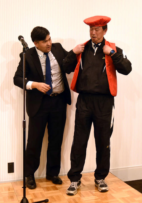 仙台育英監督時代の教え子、元楽天木村に赤いちゃんちゃんこを着せてもらう、学法石川・佐々木監督（右）（撮影・相沢孔志）