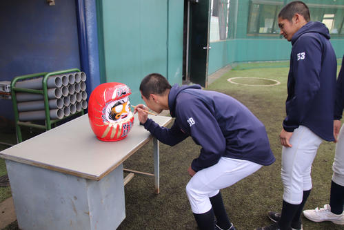 山梨学院　今年の必勝を祈願し、全員でだるまの目入れを行う選手たち（撮影・保坂淑子）