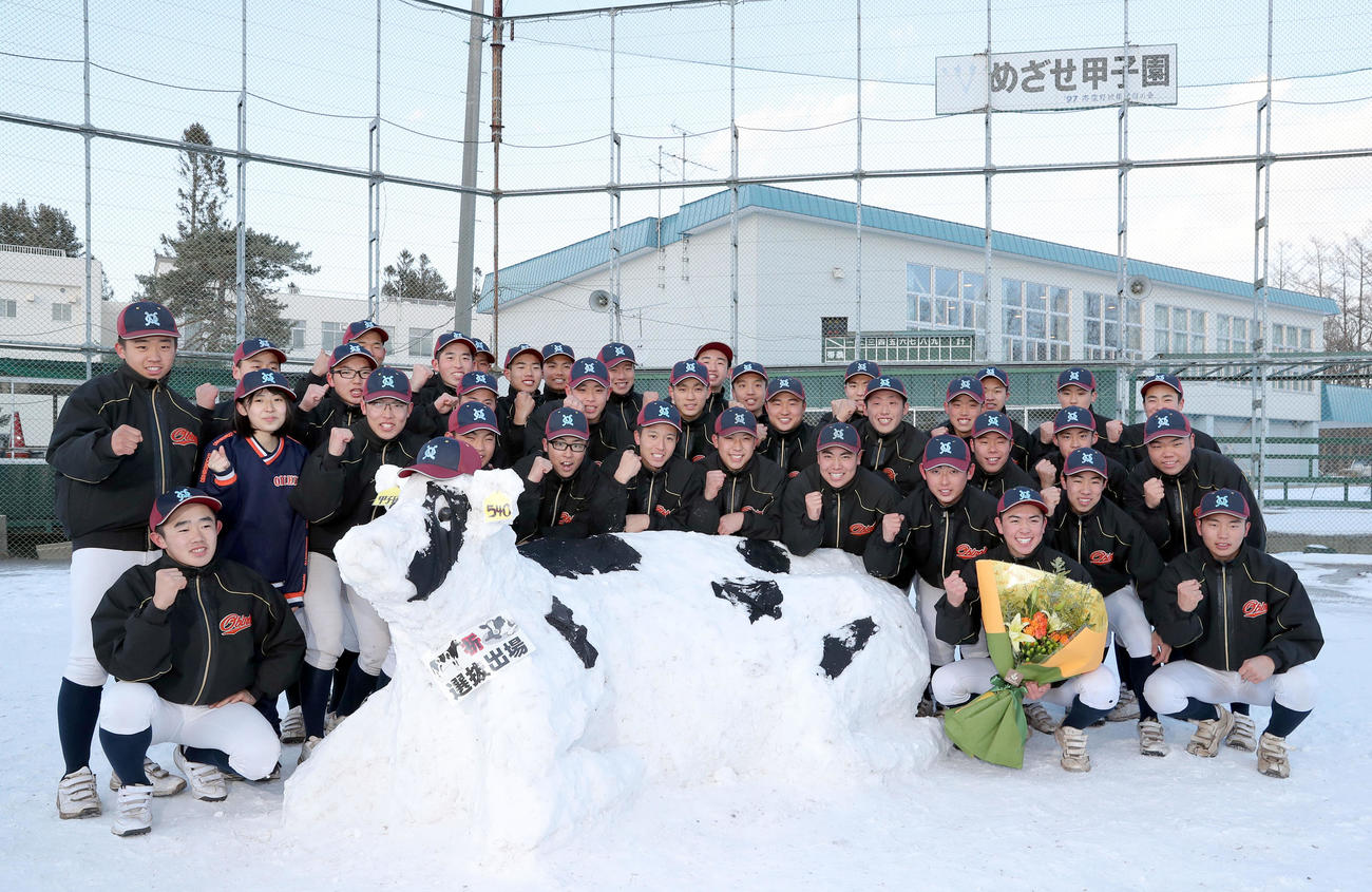 雪で作られた牛と共に撮影に応じる帯広農ナイン（撮影・佐藤翔太）