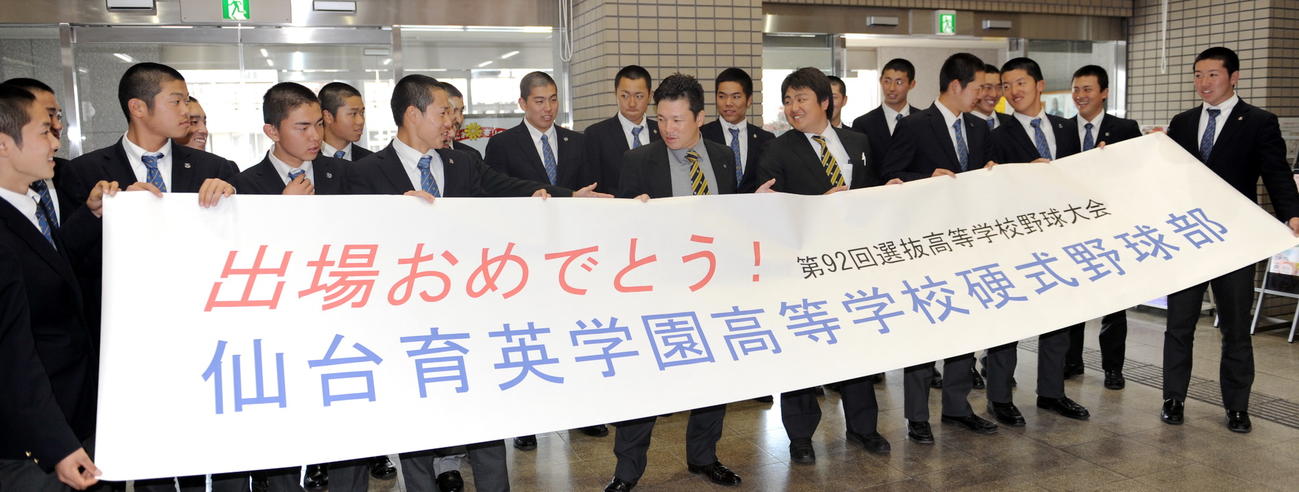 須江監督（前列中央）ら仙台育英ナインは表敬訪問した多賀城市から祝福の横断幕を送られて笑顔