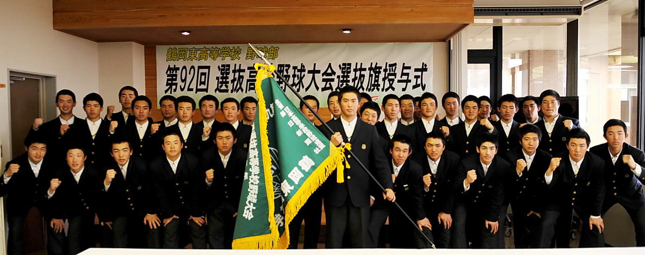 選抜旗を手にする鶴岡東・鈴木主将と野球部員