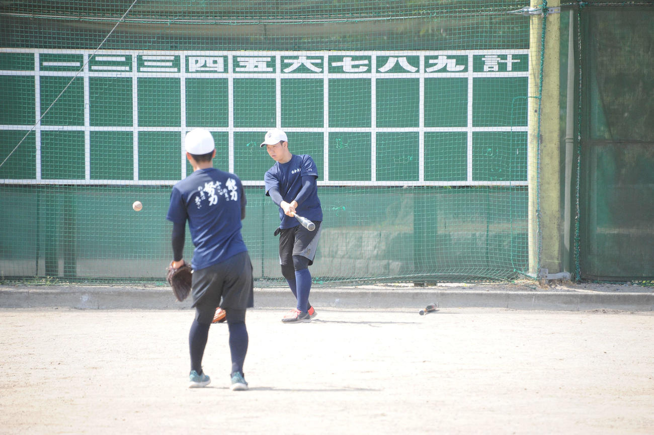トス打撃に取り組む平野主将（右）