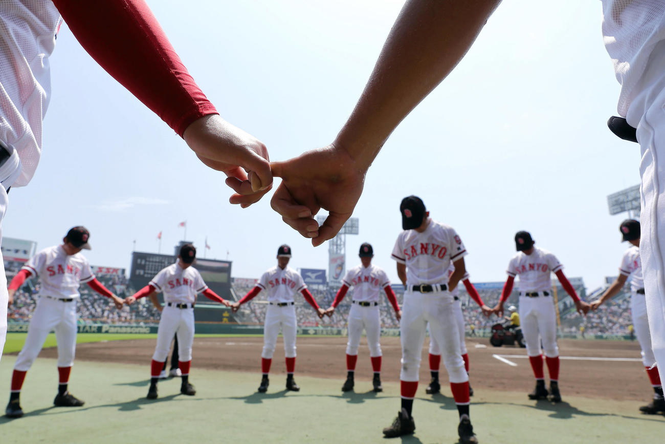 17年8月10日、聖光学院対おかやま山陽　試合前、目を閉じ手を取り合い気持ちを落ち着かせるおかやま山陽ナイン